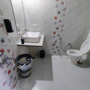 a white bathroom with a sink and a toilet at Valley Nest for 6-12 PAX in Mount Ābu