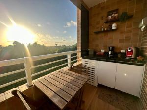 a balcony with a table and a kitchen with a view at Gran Lençóis Flat Barreirinhas APT 510 in Barreirinhas