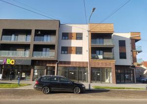 a black car parked in front of a building at APARTMAN ANDREA in Leskovac