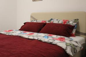 a bed with red and white blankets and pillows at Apartman 19 in Pale