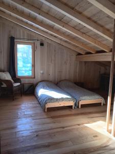 um quarto com 2 camas num chalé de madeira em Lodges Clara Vallis em Clairvaux-les-Lacs