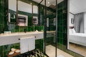 a bathroom with a green tiled wall at Hotel Tres Reyes San Sebastián in San Sebastián