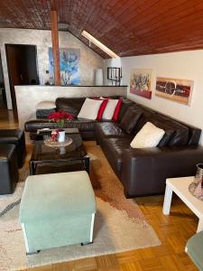 a living room with a leather couch and a table at Roba's Apartment in Zagreb