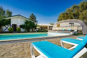 a pool with two lounge chairs next to a house at Casa Augsburg in Băneşti