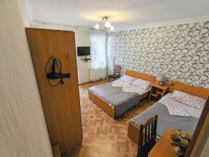 a room with two beds and a couch and a table at Paata's Guesthouse in Borjomi