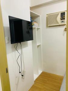 a room with a tv on the wall and a fan at Laureano Trevi Residences Makati Suites Condotel in Manila