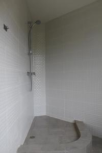 a shower in a bathroom with white tiles at Villa Neubad in Saulkrasti