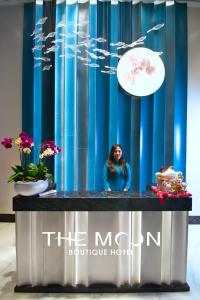 The Moon Boutique Hotel Cat Ba في كات با: امرأة تقف أمام ستارة زرقاء