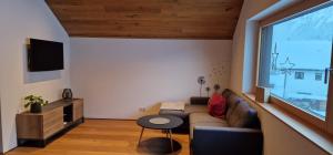uma sala de estar com um sofá e uma grande janela em Haus Moosbrugger em Mellau