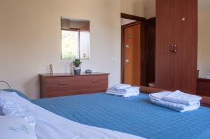 una camera da letto con un letto blu con due asciugamani sopra di Appartamentino a Susegana a Susegana