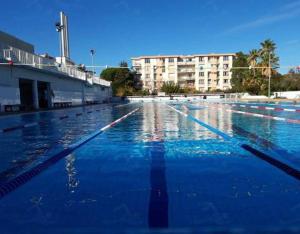 an empty swimming pool with blue water and buildings at La Suite Sainte Claire in Hyères