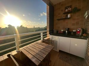 a balcony with a table and a kitchen with a view at Gran Lençóis Flat Barreirinhas Apt 509 in Barreirinhas