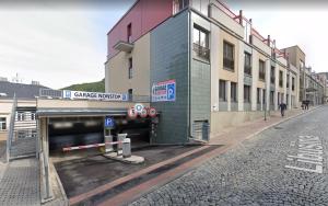 a parking garage on a street next to a building at Residence Moravia Apartments in Karlovy Vary