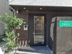 een ingang van een gebouw met een bord op de deur bij HOTEL PRELE ホテル プレール in Tokyo