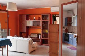 un soggiorno con pareti arancioni e una cucina di Appartamentino a Susegana a Susegana Altre 4 foto