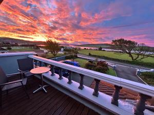 a sunset on the balcony of a house at Cill Bhreac House B&B in Dingle
