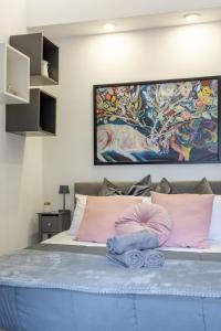1 cama con almohadas rosas y una pintura en la pared en Holiday Homes Rome - Portuense 21 - Studio with little private Garden, en Roma