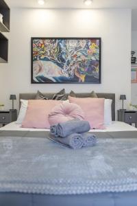 Un dormitorio con una cama con almohadas rosas y una pintura en Holiday Homes Rome - Portuense 21 - Studio with little private Garden, en Roma
