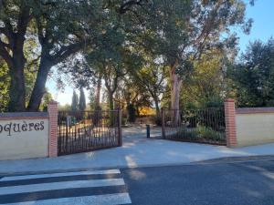 a gate in a park with trees and a sidewalk at Gite fatima in Théza