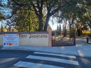 une porte menant à un parc avec un panneau. dans l'établissement Gite fatima, à Théza