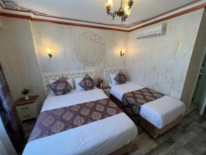 a bedroom with two beds and a chandelier at Aldem Hotel in Istanbul