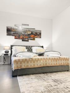 a bedroom with a large bed with a picture on the wall at Modern living: Hamburg & Baltic Sea within 30 min in Ahrensburg