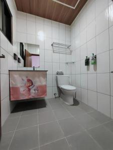 a bathroom with a toilet and a picture of a baby at 金廈之星 in Jinning