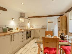 a kitchen with white cabinets and a table with chairs at 2 Bed in Woolacombe 28803 in Bittadon