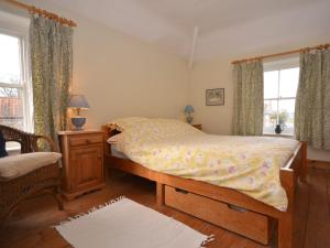 a bedroom with a bed and a chair and a window at 2 bed in Binham 26324 in Binham