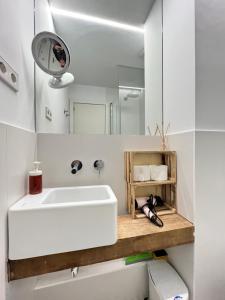 a bathroom with a white sink and a mirror at Atico LaLatina Maldonadas in Madrid