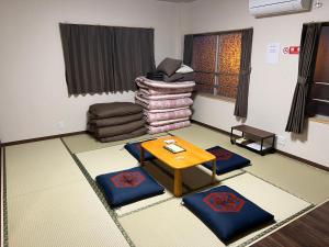 a living room with a table and a pile of blankets at 長徳寺宿坊　Temple Hotel in Shingu