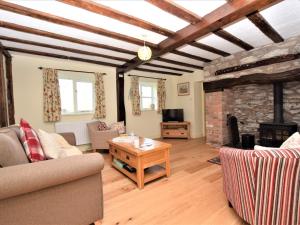 a living room with a couch and a stone fireplace at 2 bed in Oswestry Powys 36577 in Pen-y-bont-fawr