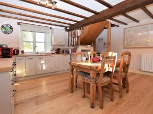 a kitchen with a wooden table and chairs in a kitchen at 2 bed in Oswestry Powys 36577 in Pen-y-bont-fawr