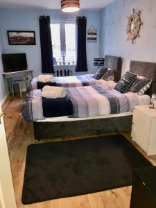 Cama grande en habitación con TV en Swanning Off Whitby with Parking, en Whitby