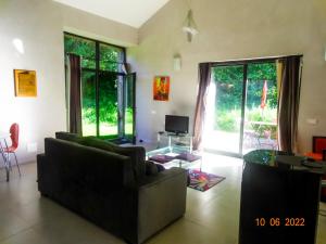 a living room with a couch and a table and a tv at Domaine de La Maison d'Aum in Bourrou