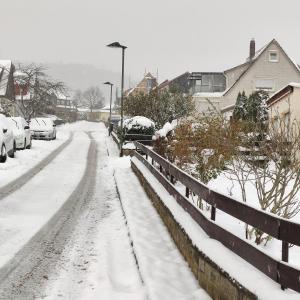 een straat vol sneeuw met geparkeerde auto's bij Gästehaus Familie Rinke in Bad Harzburg