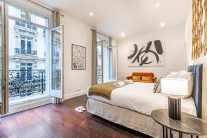 Schlafzimmer mit einem Bett und einem Tisch in der Unterkunft Sweet Inn - Triangle d'Or in Paris
