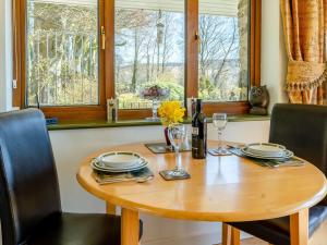 a wooden table with plates and glasses and a bottle of wine at 1 Bed in Tregaron 43288 in Tregaron