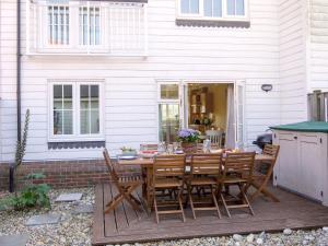 a wooden table and chairs on a patio at 4 Bed in Camber BT091 in Camber