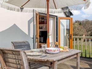 a wooden table with an umbrella on a patio at 1 bed in Beaulieu Heath NFL87 in Exbury