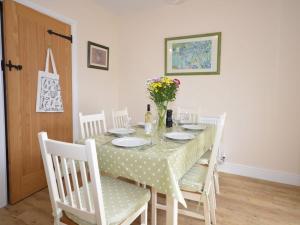 a dining room table with white chairs and a table with flowers at 3 bed property in Watchet OLDMW in Watchet