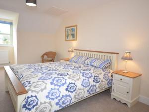 a bedroom with a bed with a blue and white comforter at 3 bed property in Watchet OLDMW in Watchet