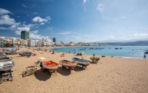 uma praia com barcos e pessoas na água em Catalina Downtown By CanariasGetaway em Las Palmas de Gran Canaria