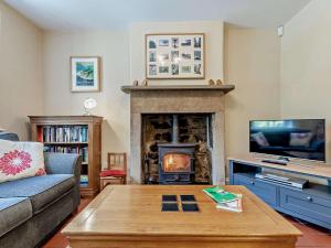 a living room with a fireplace and a tv at 3 Bed in Baslow PK908 in Baslow