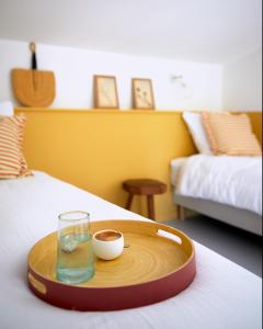 ein Tablett mit einem Glas Wasser und einer Schüssel auf einem Bett in der Unterkunft Petit coin de paradis avec jardin privé et piscine in Saint-Maximin-la-Sainte-Baume