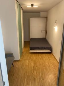 Camera piccola con letto e pavimento in legno. di Cosy Apartment - Central Station a Vienna