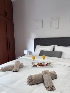 ein Bett mit einem Tablett mit Essen und zwei Gläsern Wein in der Unterkunft Nektar Suites in Kavala
