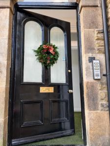 uma porta preta com uma coroa de flores em 2 Bed ground floor apartment, sleeps 4 with free parking em Harrogate