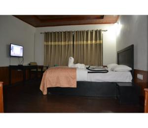 una camera d'albergo con un letto e un asciugamano sopra di Hotel Aksa Resort, Pahalgam a Pahalgam