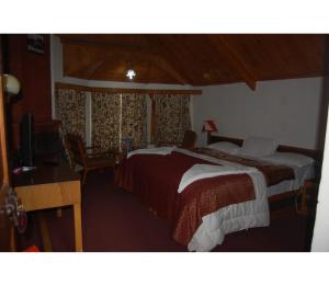 una camera con letto, scrivania e TV di Hotel Aksa Resort, Pahalgam a Pahalgam